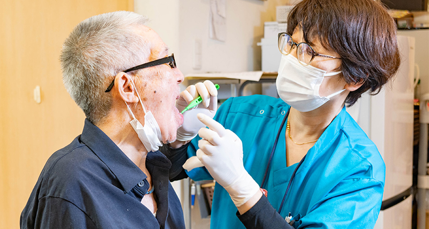 訪問診療 患者が医師から歯の検査を受けている様子