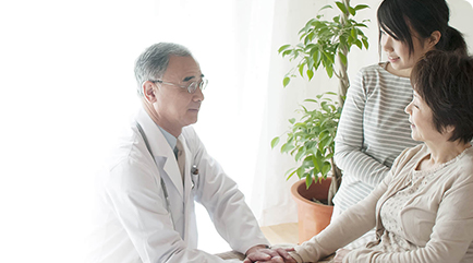 ベッドに横になっている患者と医師が会話をしている様子